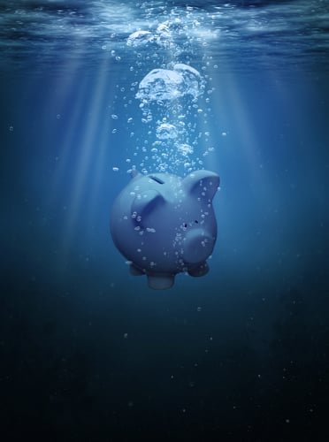 Piggy bank drowning in the ocean