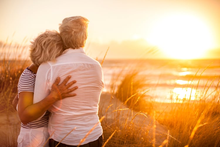 A couple at a lake deciding if they should take social security benefits