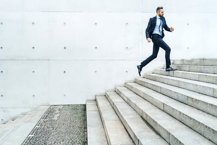 Young businessman running on stairs in the street