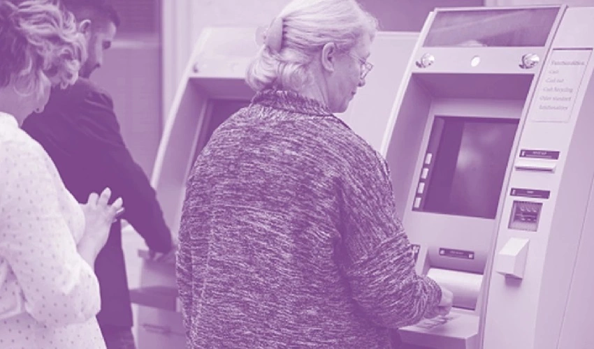 Elderly lady at an ATM postponing her retirement