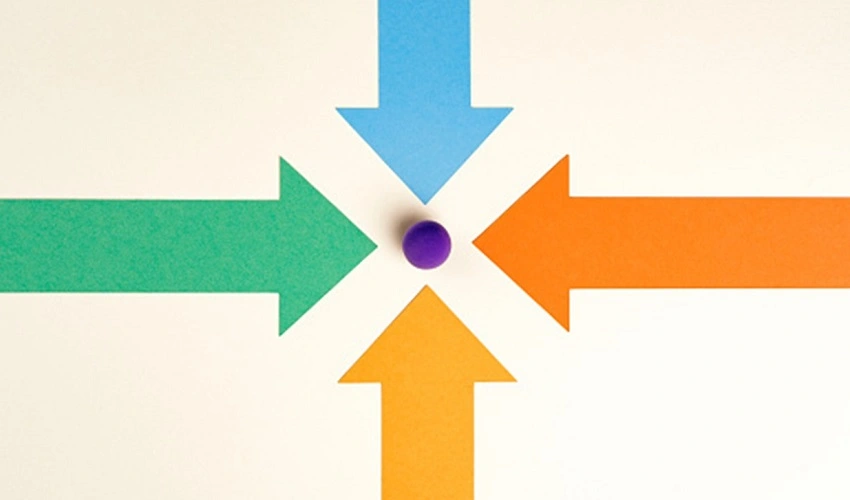 four multi colored arrows pointing toward purple ball